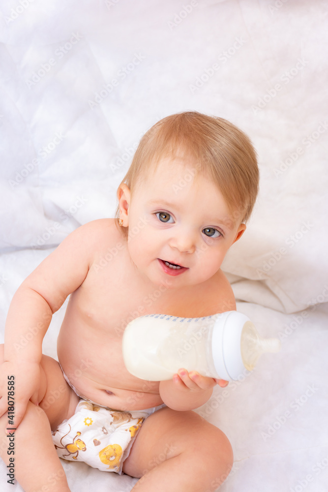 happy little girl holding a bottle of baby food milk. Baby food. concept of artificial feed. happy little girl holding a bottle of baby food milk. Baby food. concept of artificial feed.
