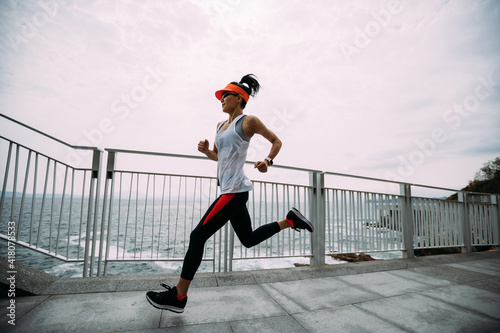 Healthy lifestyle fitness sports woman runner running on seaside trail