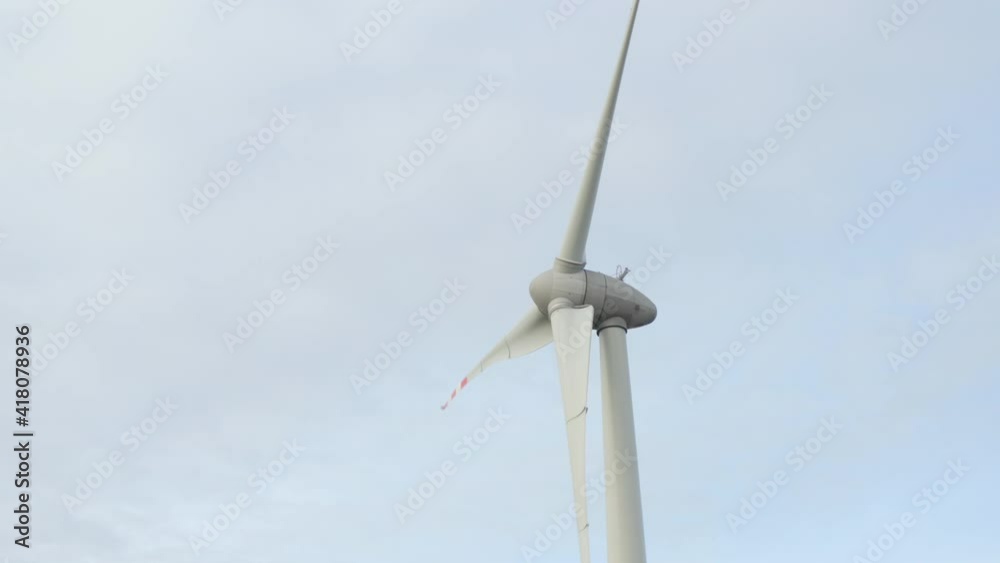 Aerial close up shot of Wind Turbine. Generating renewable energy and in the background an ecological farm.
Aerial close up shot of Wind Turbine. Generating renewable energy and in the background an ecological farm.