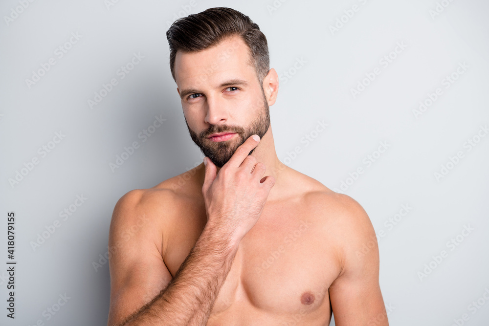 Close-up portrait of attractive content perfect well-groomed brunet guy touching chin isolated over light grey color background Close-up portrait of attractive content perfect well-groomed brunet guy touching chin isolated over light grey color background