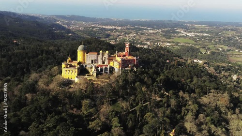 A 4K high view of Pena Palace in Sao Pedro de Penaferrim surrounded by forests in Portugal photo