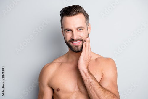 Photo of young handsome man happy positive smile enjoy fresh pure skin hand touch cheek isolated over grey color background