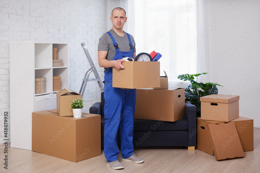 young handsome loader standing in room with box in hand young handsome loader standing in room with box in hand