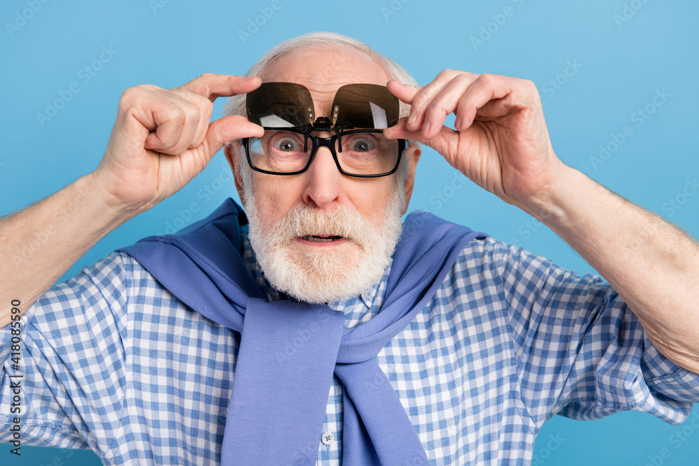 Photo of impressed old grey hairdo man touch spectacles wear blue shirt isolated on pastel color background Photo of impressed old grey hairdo man touch spectacles wear blue shirt isolated on pastel color background