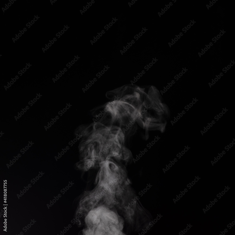 Curly white steam rising up and splashing water scattering in different directions isolated on a black background.