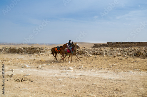 Cairo / Egypt - February 09 2021: A horseman riding in Giza Pyramids area. Horseback and camel riding are traditional rituals at the grounds of Giza Pyramids.