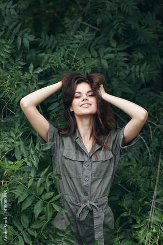woman in forest Brunette green jumpsuit bushes nature trees 