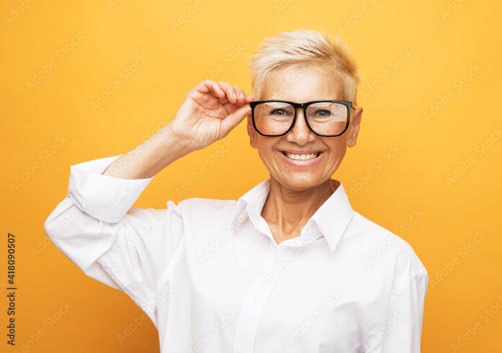 Old senior woman wear eyeglasses over yellow background. Old senior woman wear eyeglasses over yellow background.