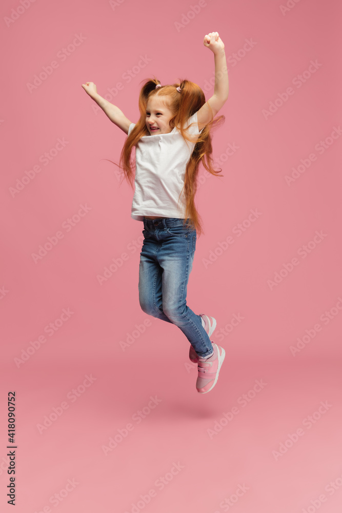 Jumping, running. Happy, smiley little caucasian girl isolated on pink studio background with copyspace for ad. Looks happy, cheerful. Childhood, education, human emotions, facial expression concept. Jumping, running. Happy, smiley little caucasian girl isolated on pink studio background with copyspace for ad. Looks happy, cheerful. Childhood, education, human emotions, facial expression concept.