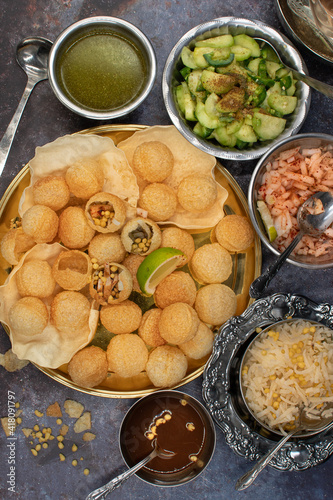 Indian pani puri served with potato, pickles and chutneys