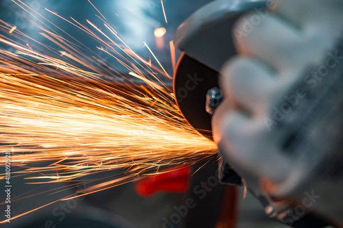 cutting metal pipe grinder in the workshop with sparks on the workbench