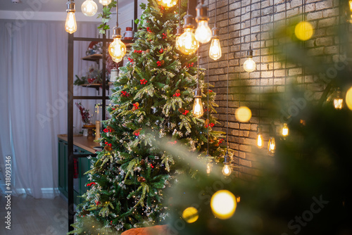 Merry Christmas and New Year holidays background. Beautiful decorated christmas tree. Beautiful decorated fireplace and Christmas tree at cottage.