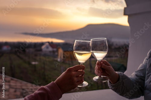 toast with wine glasses at lake Balaton with the Badacsony hill in the background photo