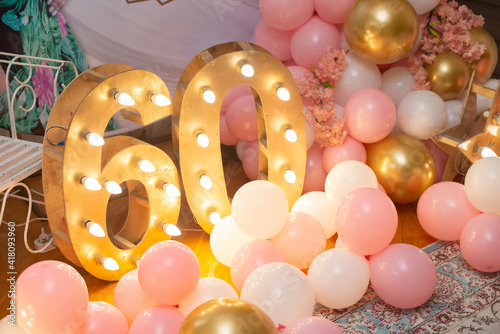 Happy birthday! BIrthday decoration for sixty years old. Pink balloons and lights.