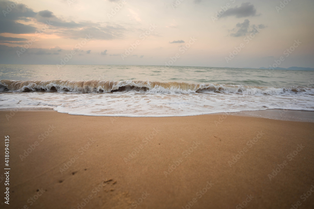 White waves on the beach in the morning, dark tones. White waves on the beach in the morning, dark tones.