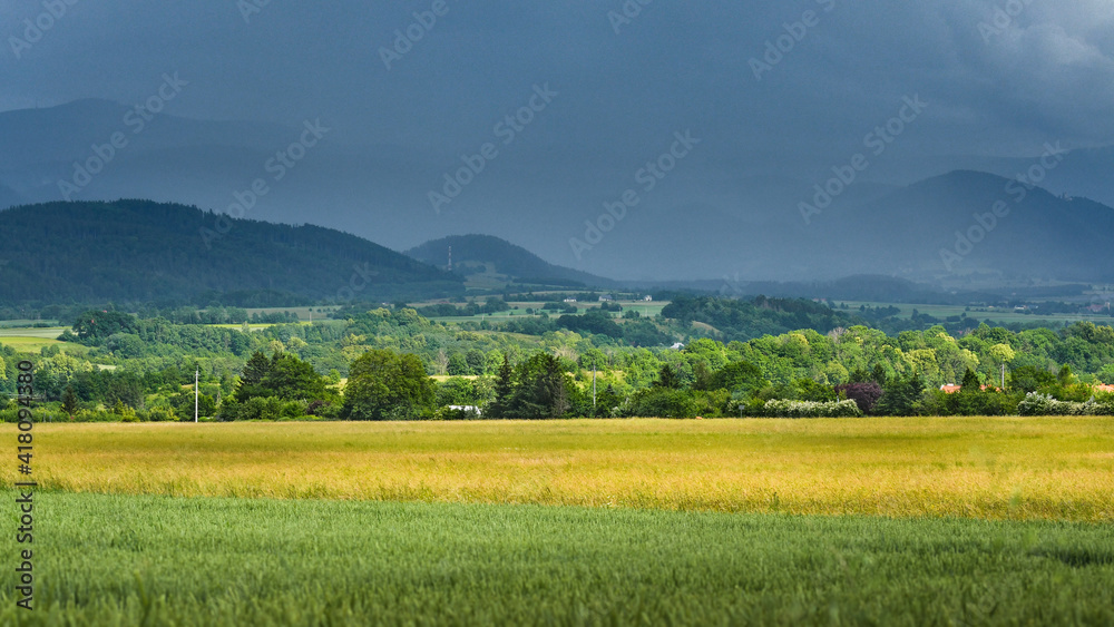 A storm front with rain comes from the mountains.