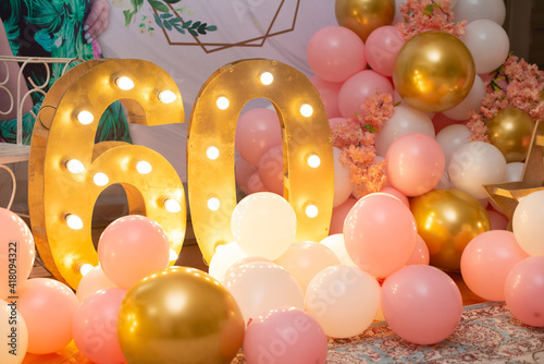 Happy birthday! BIrthday decoration for sixty years old. Pink balloons and lights.