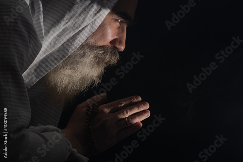 Obraz na plátne A senior man standing in dark smoky background light ray from above