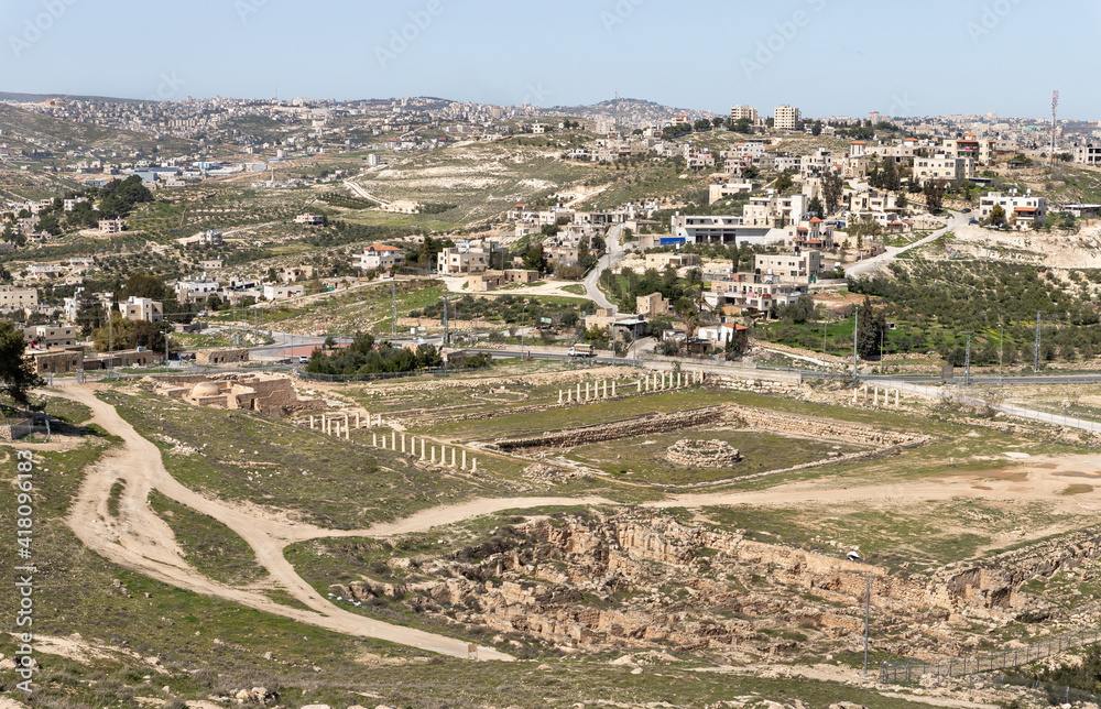 View  from the walls of the ruins of the palace of King Herod - Herodion of the the ruins of the lower part of the palace and nearby Jewish and Arab settlements in the Judean Desert, in Israel