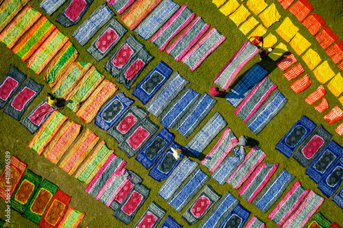 Aerial view of people working in a public laundry draining and drying colourful clothes at sunlight, Araihazar, Dhaka province, Bangladesh. photo