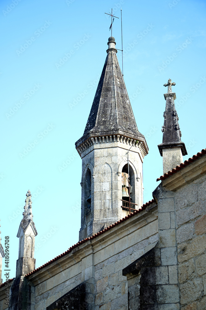 Gothic stone church steeple with ornaments and blue sky