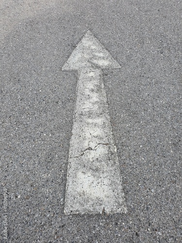 The old white arrow direct traffic sign on the road.