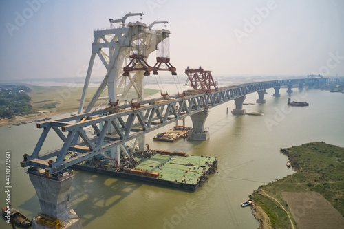 Aerial view of a building site while assembling the Padma bridge, the longest rail and highway bridge in Bangladesh crossing the Padma river, Zajira, Dhaka, Bangladesh. photo