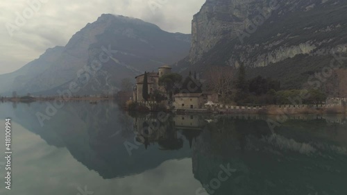 Aerial approach over Lake Toblino of Castle Toblino - Castello Toblino in Alpine setting near Trentino in Northern Italy. High quality 4k footage photo