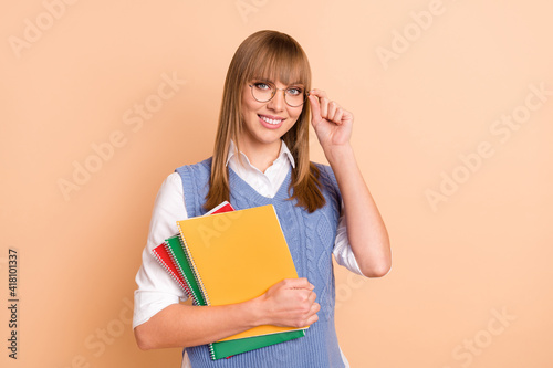 Photo portrait of pretty woman keeping pile books smiling wearing formalwear eyewear isolated on pastel beige color background