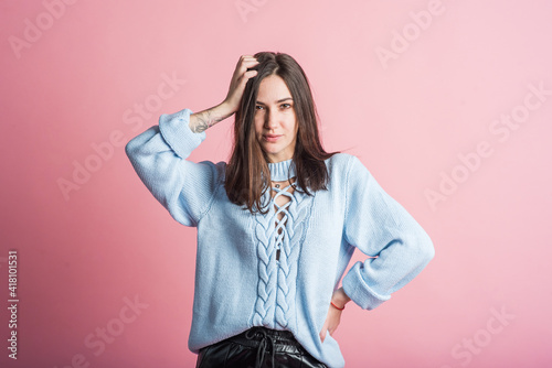 Portrait of a brunette girl on a pink background who is happy and smiling