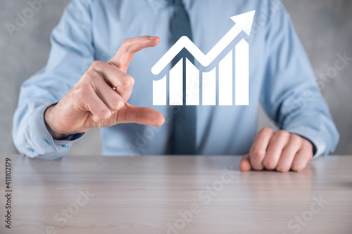 Businessman man holding a graph with positive profits growth. plan graph growth and increase of chart positive indicators in his business.more profitable and growing.