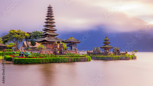 Pura Ulun Danu Bratan temple in Bali island. Beautiful balinese temple during sunrise. Balinese landmark. Cloudy sky. Water reflection. Slow shutter speed. Bratan lake, Bali