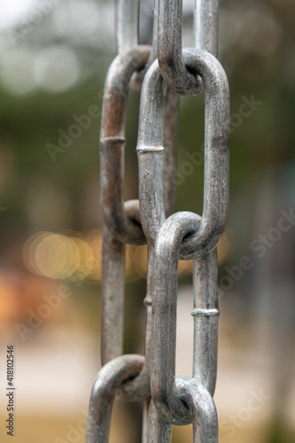 Strong shiny silver chain, outdoors, park background