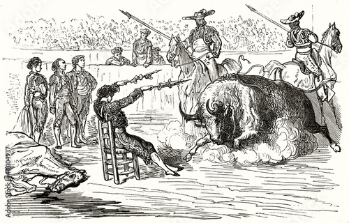 violent bullfighting in the arena between seated bullfighter against bull. Ancient grey tone rough sketch etching style art by Dore, Magasin Pittoresque, 1838 photo