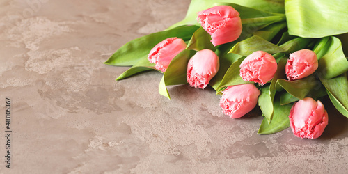 Flowers. Banner with a bouquet of pink tulips on an gray marble background. Top view with copyspace. International Women's Day, Easter, Valentines Day, spring concept.