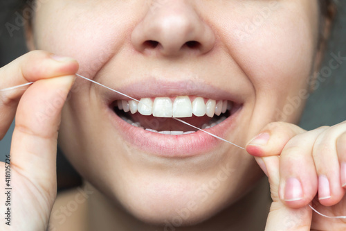 A cropped shot of a young beautiful woman flossing her teeth. Close-up. Dental concept
