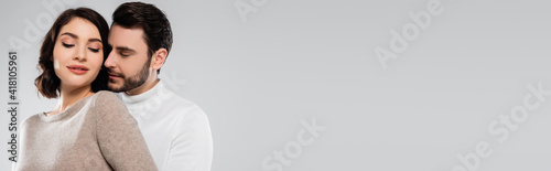 Man standing near pretty brunette woman isolated on grey, banner
