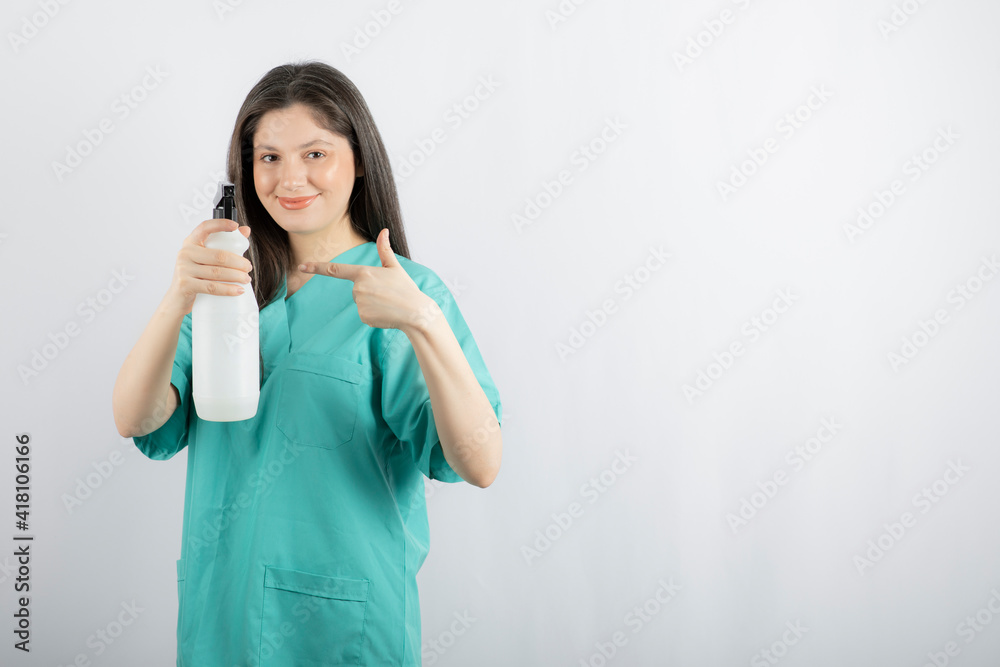 Young woman pointing finger to the disinfectant Young woman pointing finger to the disinfectant