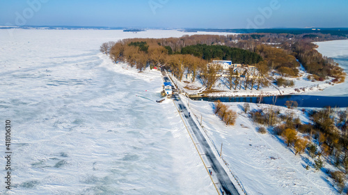 Aerial drone image of frozen lake and dam with snow. Ice from the drone view in winter. Beauty in nature concept.