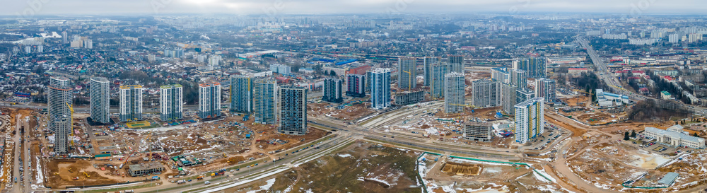 Panoramic view of construction of high-rise resedential buildings. The construction industry with working equipment. View from above. Eye bird view of new resedential district.
