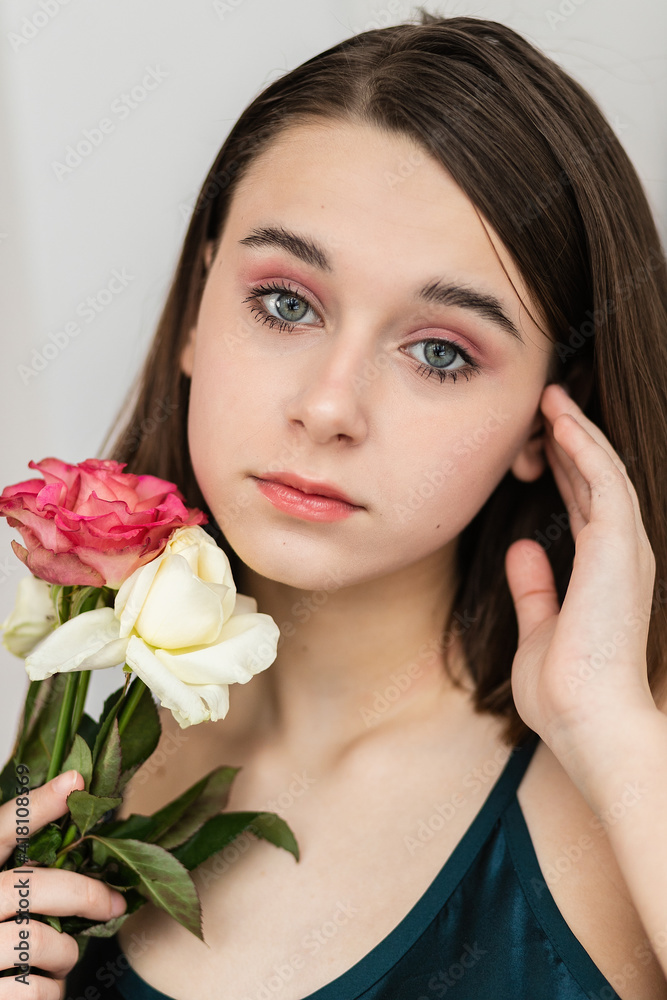 Portrait of beautiful dark-haired woman with flowers. Fashion photo, Pretty little girl with pink rose