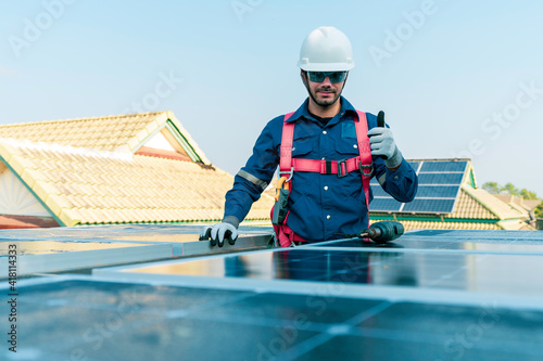 A technician action thump up during installing the solar panels at roof top of home and home office ,concept of economic energy and cost saving ,own small business,own business concept