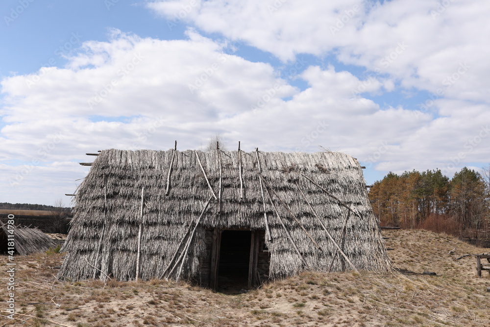 remnants of Ancient houses made from hollow logs with wooden and thatched roofs on the meadow remnants of Ancient houses made from hollow logs with wooden and thatched roofs on the meadow