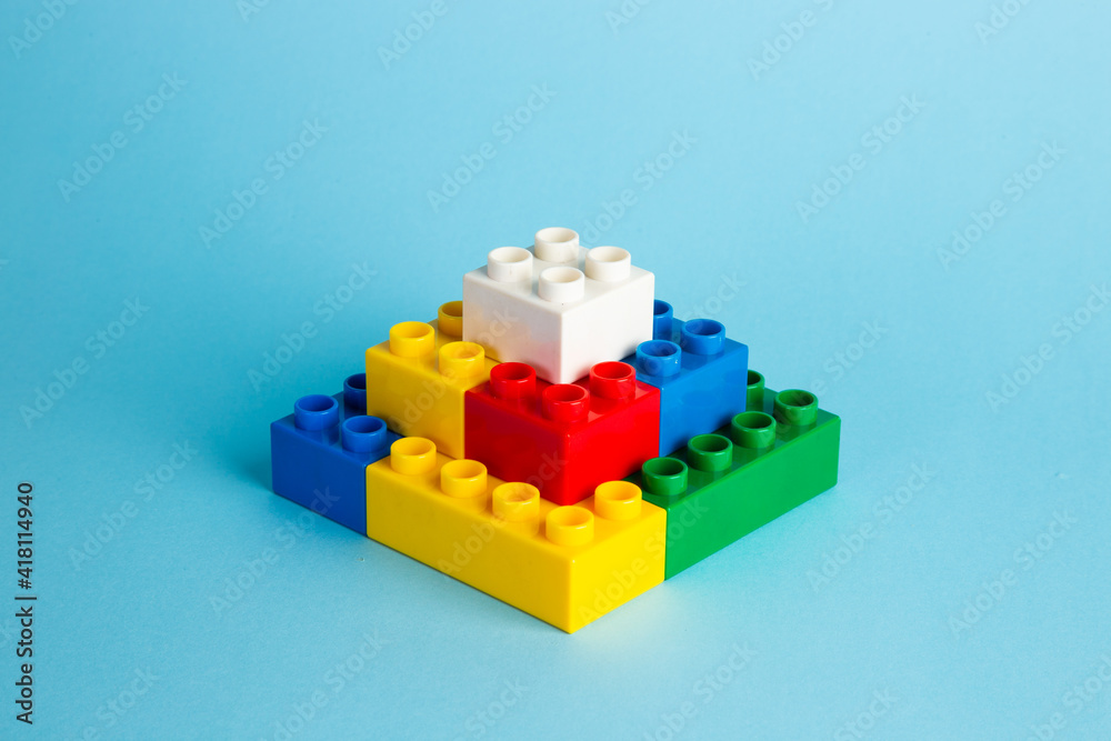 Color plastic building blocks on red background Color plastic building blocks on red background