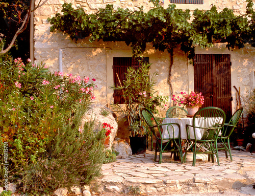 A quaint, pretty garden scene, with rustic patio furniture