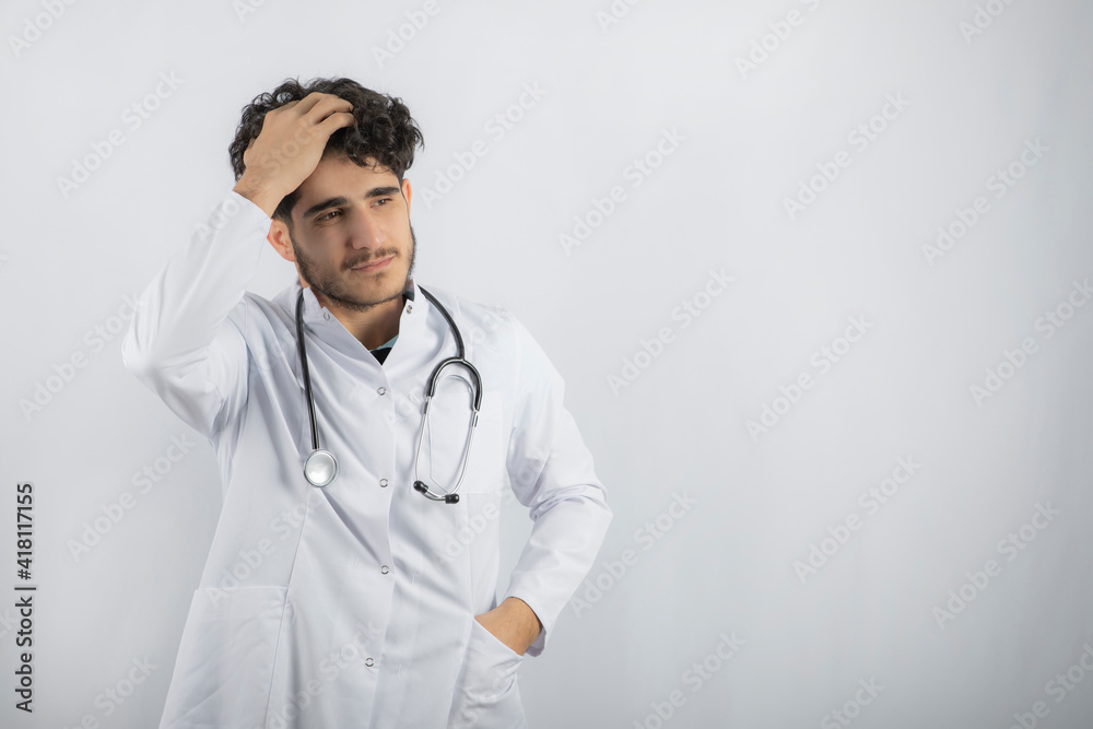 Tired doctor holding his hand to his head and look away Tired doctor holding his hand to his head and look away