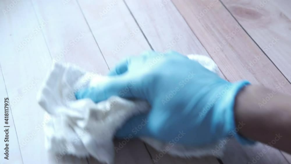 hand in blue rubber gloves holding spray bottle cleaning table hand in blue rubber gloves holding spray bottle cleaning table
