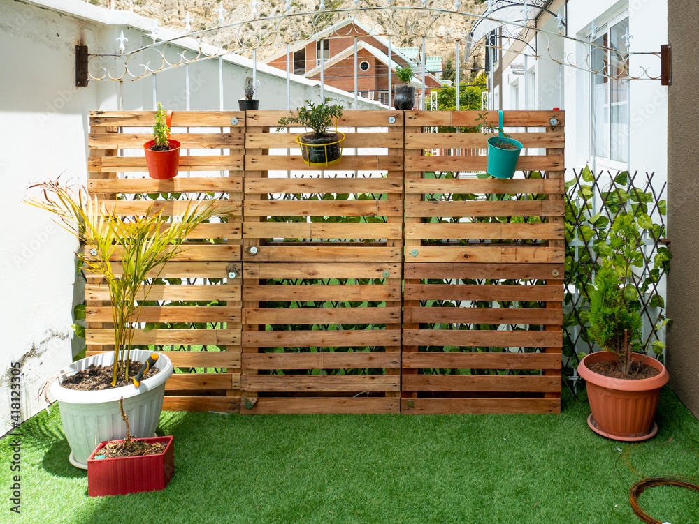 Garden with Wooden Pallets and a Few Pots Hanging on a Sunny Day
