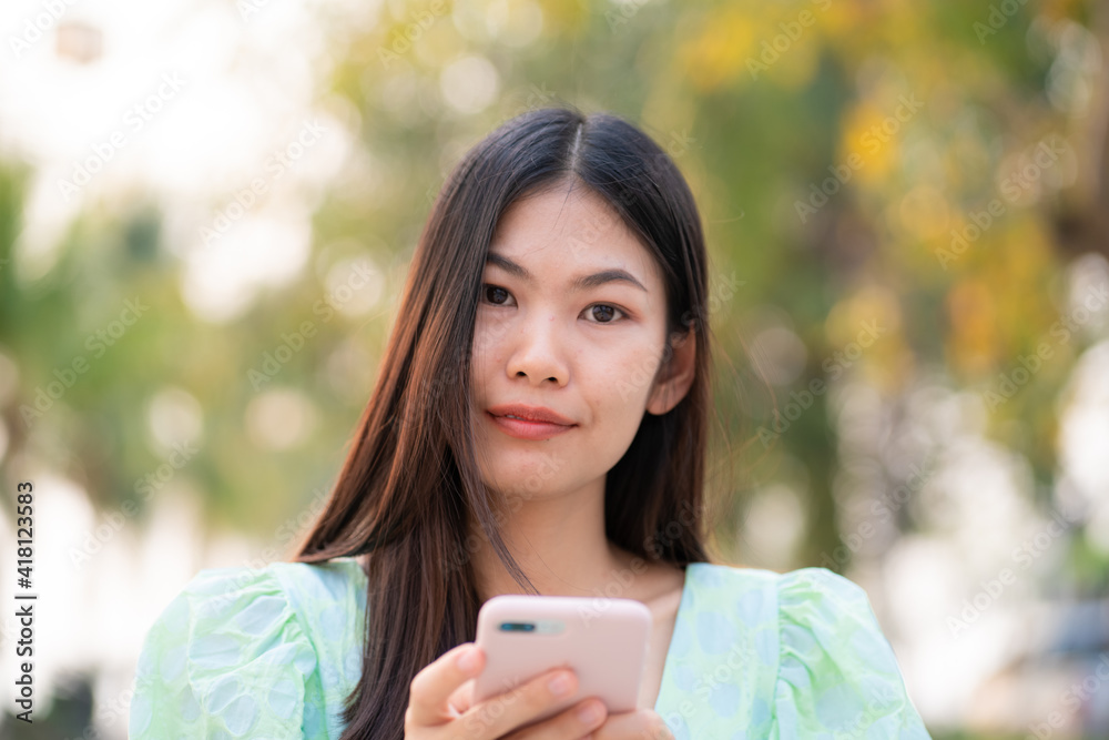 Beautiful casual women use smartphone walking in outdoor city park Beautiful casual women use smartphone walking in outdoor city park