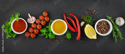 Colorful various herbs and spices for cooking on dark background